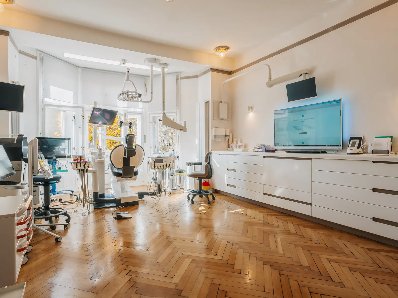 Cabinet D'Institute luminos, cu scaune stomatologice, ecrane și dulapuri albe, în clinica din Grigorescu