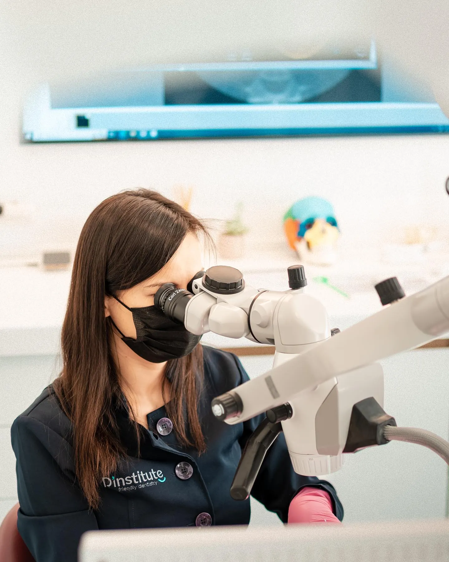 Dr. Adriana Morar, endodontics specialist at D'Institute Cluj, working at the microscope