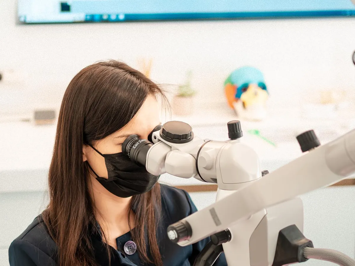 D'Institute dentist working at the dental microscope